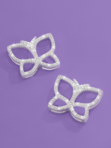 matching silver jewelry set on a purple backdrop, including a open-wing butterfly pendant necklace covered in pave crystals