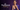 Promotional image with the Rommanel History logo on a purple curtain background, featuring a woman in a purple blazer wearing a bold gold link chain necklace, hoop earrings, and gold cuffs.