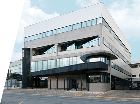Exterior view of a modern multi-story corporate building with glass windows and concrete architecture.
