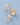 Gold choker-style chain necklace laying on a solid purple background, detailed with evenly spaced dangling charms featuring small textured seashells paired with freshwater cultured pearls.