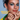 Model wears blue eye makeup, terracotta lipstick, and three intricate gold cage-style rings.