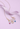 Gold safety pin necklace with various charms, including two heart-shaped ones, a blue one, and a baby's footprint charm on a light-purple background.
